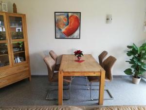 a dining room table with a heart painting on the wall at Nordzeeoase-Pethan met sauna in Neuharlingersiel