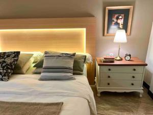 a bedroom with a bed and a nightstand with a lamp at Kallista Villa Kalibaru in Kalibaru