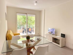 uma sala de estar com uma mesa de vidro e cadeiras em Alghero CHARMING APARTMENTS DOWNTOWN em Alghero