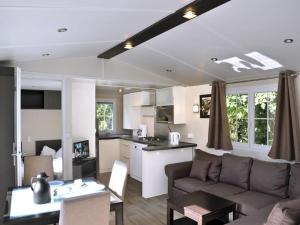 a living room and kitchen with a couch and a table at - Mobile home "Sumba" in Fehmarn +14 photos