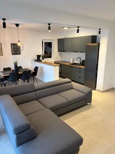 een woonkamer met een bank en een keuken bij Apartments Mima in Petrcane