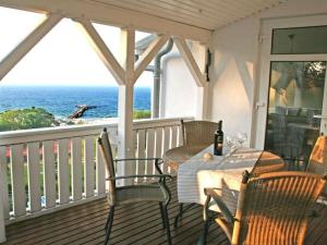 a porch with a table and chairs and the ocean at Königsstuhl Comfortable holiday residence in Göhren