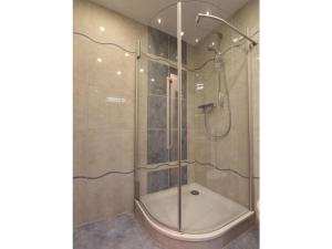 a bathroom with a shower with a glass door at Königsstuhl Comfortable holiday residence in Göhren +14 photos