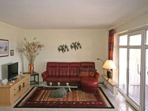 a living room with a red couch and a tv at Königsstuhl Comfortable holiday residence in Göhren