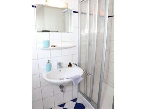 a white bathroom with a sink and a mirror at House in Legde "East" in Norderney