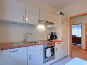 a kitchen with white cabinets and a sink at Comfortable holiday residence in Fehmarn