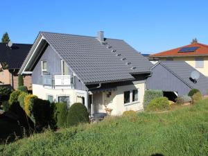 une maison blanche avec un toit gris dans l'établissement Huis op de Sonnberg - Sauna, à Auggen