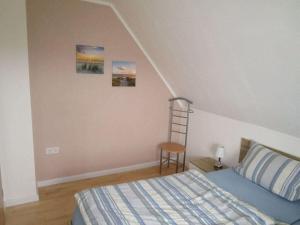a bedroom with a bed and a ladder on the wall at Nordseeoase Pethan 2 - Boven in Neuharlingersiel