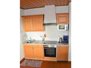 a small kitchen with wooden cabinets and a sink at Berghaus Oberleitner - peace and relaxation in Neureichenau +19 photos
