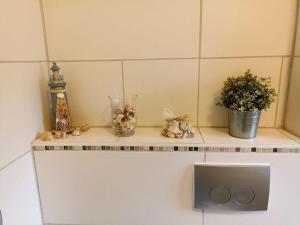 a shelf with a plant and a vase on it at Holiday home Heide Comfortable holiday residence in Bad Fallingbostel +15 photos