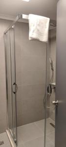 a shower with a glass door with a towel at The Yalı Konak Hotel İzmir in İzmir