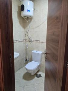 een badkamer met een toilet en een camera aan de muur bij El-Shaikh Zayed, 6 october 3BHK flat- families only in Sheikh Zayed