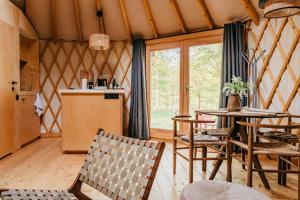 a room with a table and chairs in a room at Dacza Puchacza Glamping in Stare Osieczno