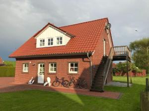 a house with two bikes parked in front of it at Haus Butje Comfortable holiday residence in Fedderwarderdeich