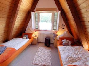 a attic bedroom with two beds and a window at Taubenweg 19 Comfortable holiday residence in Fintel