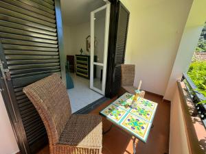 a balcony with a table and chairs and a room at Jungle Rooms in Cetara