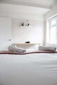 een witte kamer met een bed met 2 kussens erop bij Coastal Haven in Leigh-on-Sea in Southend-on-Sea