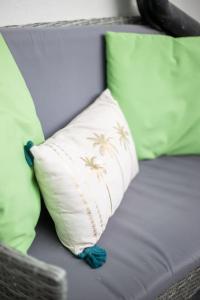 a couch with green and white pillows on it at Coastal Haven in Leigh-on-Sea in Southend-on-Sea