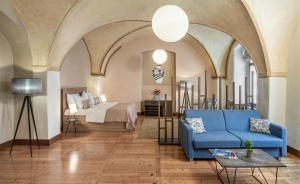 a living room with a blue couch and a bed at 3 Epoques Apartments by Adrez in Prague