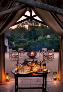 阿多的住宿－戈拉大象營酒店，露台上的桌子上摆放着食物和饮料