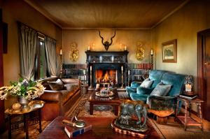 a living room with a couch and a fireplace at Gorah Elephant Camp in Addo