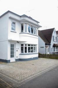 a white house with a brick driveway in front of it at Coastal Haven in Leigh-on-Sea in Southend-on-Sea