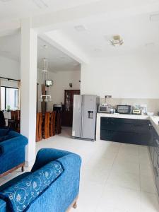 a living room with a blue couch and a kitchen at Papura Wattarappala Midland in Mount Lavinia