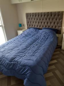 uma cama grande com um edredão azul e uma cabeceira em NV 1219 - Beach Resort Nieuwvliet Bad em Nieuwvliet
