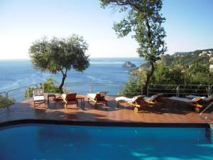 a swimming pool with chairs and a view of the ocean at Residence Borgo San Sebastiano in Bergeggi