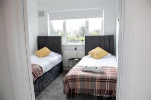 a bedroom with two beds and a mirror at Stylish Retreat in Leigh-on-Sea in Southend-on-Sea