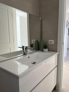 W łazience znajduje się umywalka i lustro. w obiekcie La Casa di Spinosella w mieście Valledoria