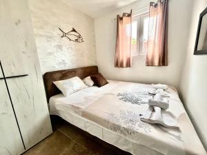 1 dormitorio pequeño con 1 cama con sábanas blancas en Apartments Obradovic en Krasići