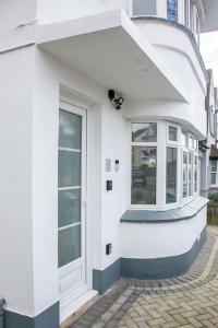 a white building with a door on a street at Stylish Retreat in Leigh-on-Sea in Southend-on-Sea