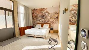 um quarto de hotel com uma cama e um quadro na parede em AUX DUCS DE SIENNE em Montagne
