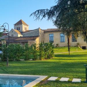 a house with a pool in front of a yard at AUX DUCS DE SIENNE in Montagne