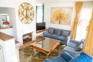 Sala de estar con sofás azules y mesa de centro en Villa Radiante 10 de la playa en Sant Vicenç de Montalt