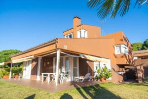 una casa con una gran terraza frente a ella en Villa Radiante 10 de la playa en Sant Vicenç de Montalt