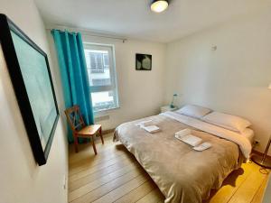a bedroom with a bed with two towels on it at 3BR Zeedijk apartment Ocean View in Blankenberge