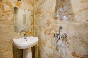 a bathroom with a sink and a mirror at FabHotel JP Villa in Varanasi