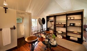 Zimmer mit einem Zimmer mit einem Bett und einem Tisch in der Unterkunft Gorah Elephant Camp in Addo
