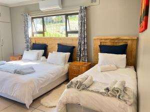 a bedroom with two beds and a window at La Vue in Port Shepstone