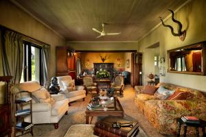 a living room with couches and a fire place at Gorah Elephant Camp in Addo