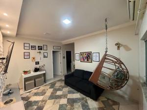 Apartamento completo e elegante, BEM LOCALIZADO. في بوتو فيلهو: غرفة معيشة مع أريكة ومرجيح