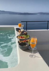 a table with food and wine on a boat at Platis Residence Villa in Oia