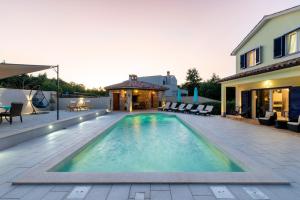 una piscina en un patio trasero con una casa en Villa Rose near Labin - Rabac for 4 people with playground and private pool, en Kršan