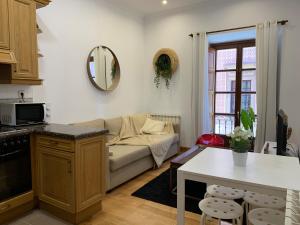 a living room with a couch and a table at MyHouseSpain - Acogedor apartamento plaza mayor Gijón 1 in Gijón +11 photos