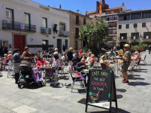 a crowd of people sitting at tables in a courtyard at COLIBRI in Calella