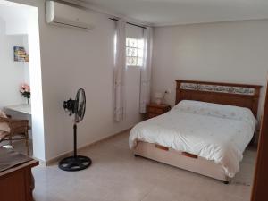 a bedroom with a bed and a fan in it at Pete's Place in La Marina