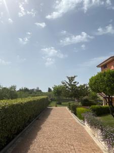 a brick walkway in a park with bushes at Villa Laregina in Grisolia