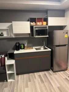 a small kitchen with a sink and a refrigerator at Casa Bondia in Bangkok